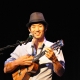 Picture of JAke Shimabukuro playing ukulele in concert.
