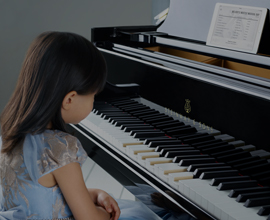 a little girl playing a spirio piano