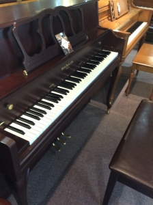 upright piano with a bench in front of it