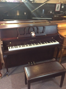 upright piano with a bench in front of it