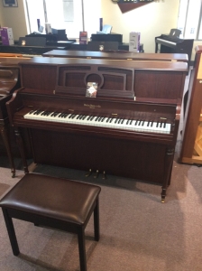 brown upright piano with bench made by hallet davis