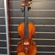 brown violin hanging on a black wall