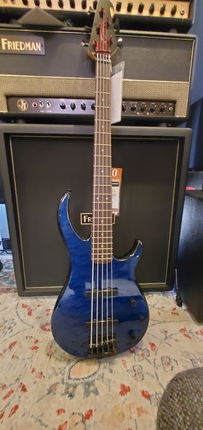 Blue Peavey Mellinium BXP 5 String Bass leaning against an amp